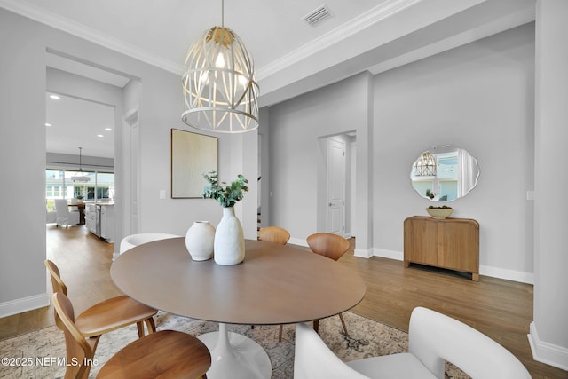 dining space with visible vents, an inviting chandelier, and wood finished floors