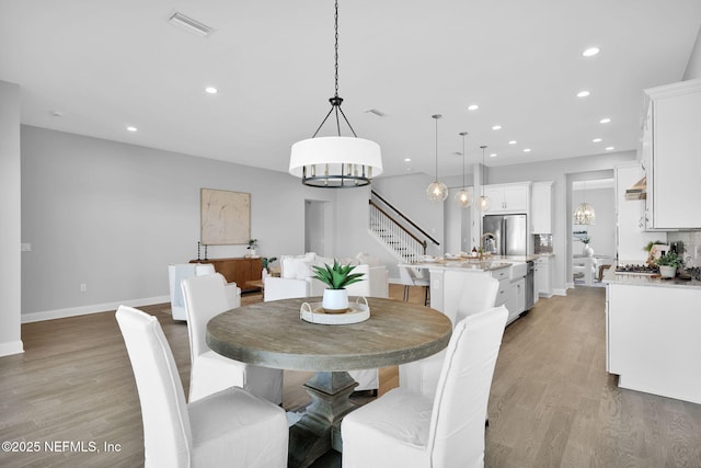 dining area featuring recessed lighting, stairs, and light wood-style floors