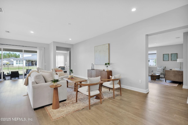 living room with recessed lighting, baseboards, and light wood-style floors