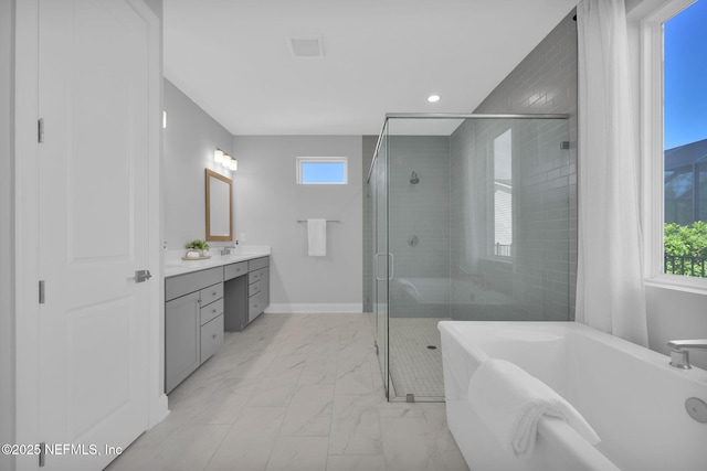 bathroom with vanity, a healthy amount of sunlight, a stall shower, a freestanding bath, and marble finish floor