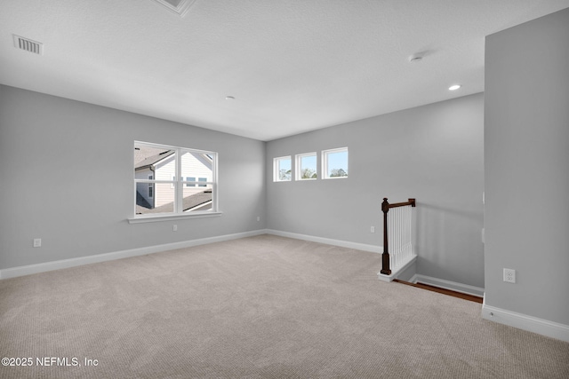 spare room with visible vents, recessed lighting, carpet, and baseboards