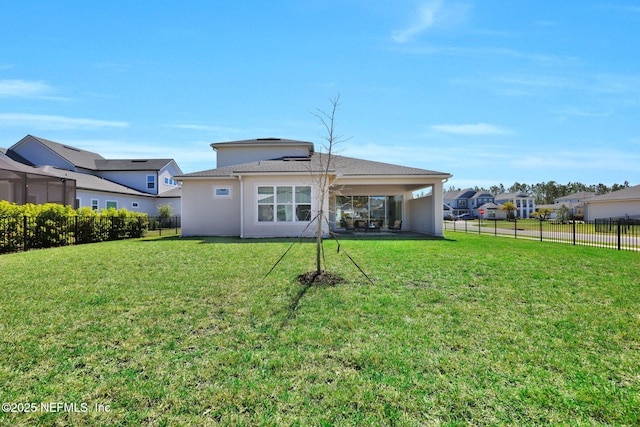 rear view of property featuring a lawn and a fenced backyard