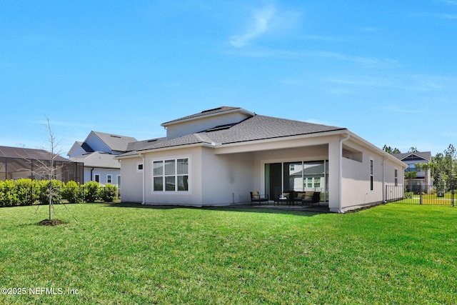 back of property featuring a yard, stucco siding, and fence