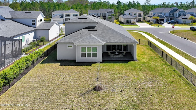 rear view of property with a yard, a residential view, a fenced backyard, and stucco siding