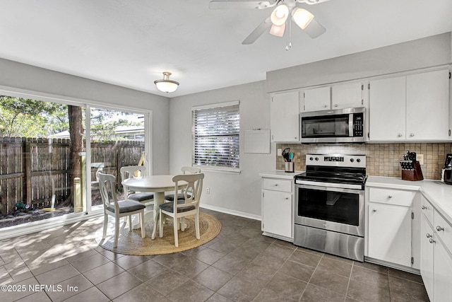 kitchen with light countertops, white cabinets, backsplash, and appliances with stainless steel finishes