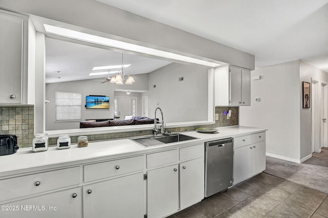 kitchen featuring lofted ceiling, a sink, light countertops, white cabinets, and stainless steel dishwasher