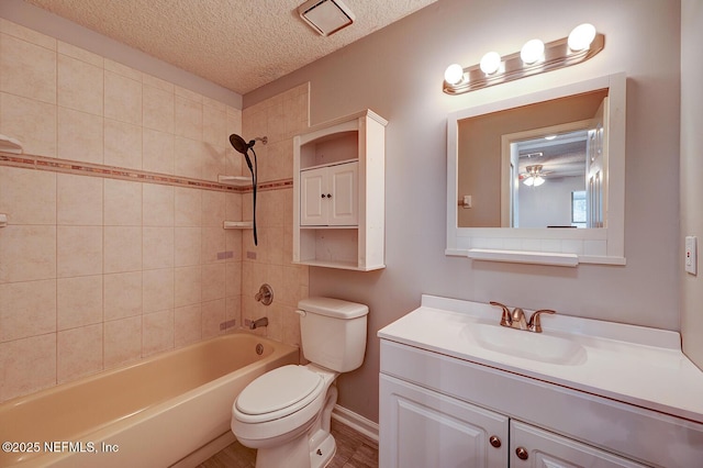 bathroom with vanity, toilet, shower / bathtub combination, and a textured ceiling