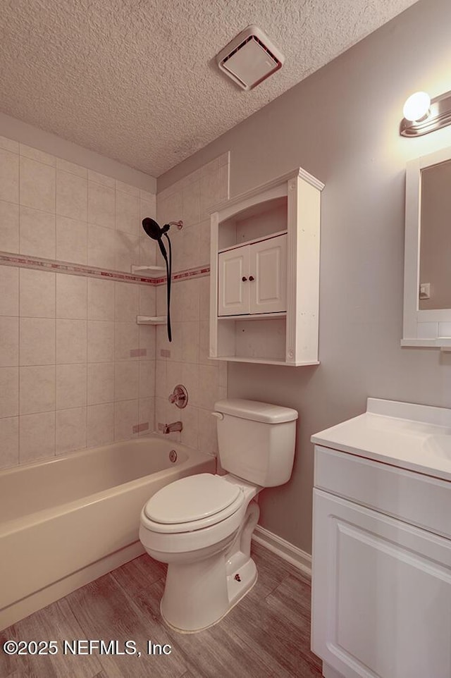 full bath featuring toilet, a textured ceiling, shower / bathtub combination, and wood finished floors