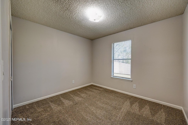 carpeted spare room featuring baseboards and a textured ceiling