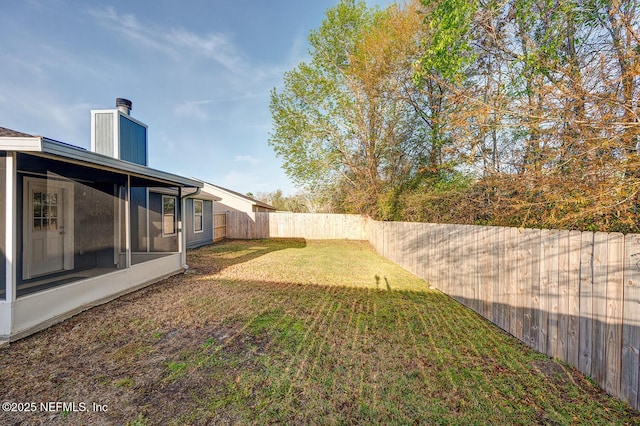 view of yard with a fenced backyard and a sunroom