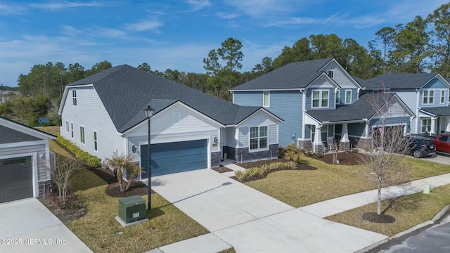 view of front of house with driveway, stone siding, a front yard, a shingled roof, and a garage