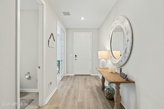 interior space with visible vents, light wood-type flooring, and baseboards