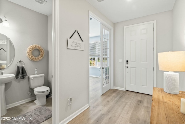 entryway featuring visible vents, baseboards, and light wood finished floors