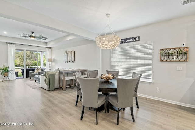 dining room featuring visible vents, ceiling fan with notable chandelier, light wood-type flooring, and baseboards