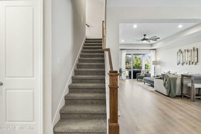 staircase featuring recessed lighting, baseboards, a ceiling fan, and wood finished floors