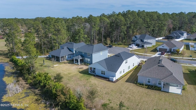 bird's eye view featuring a wooded view and a residential view