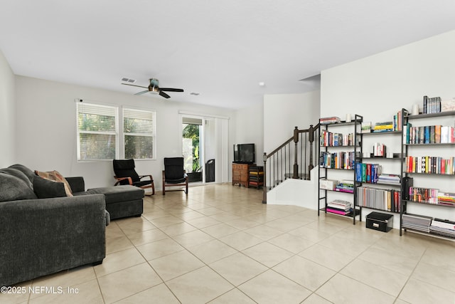 living room with light tile patterned floors, visible vents, and ceiling fan