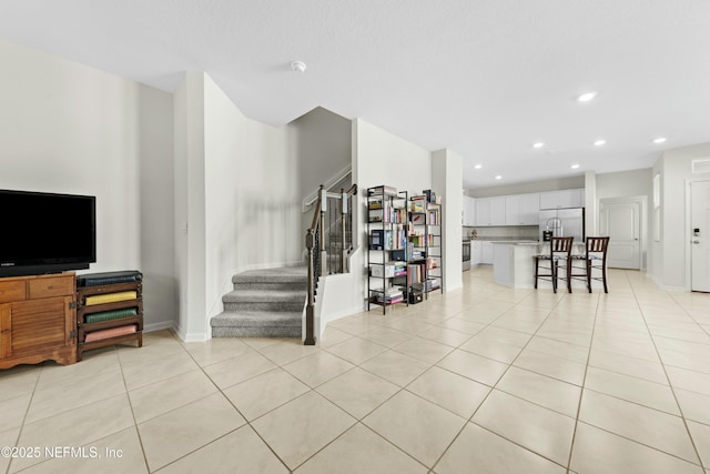 living room with stairway, light tile patterned flooring, recessed lighting, and baseboards