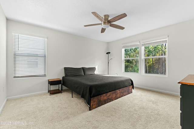 carpeted bedroom featuring ceiling fan and baseboards