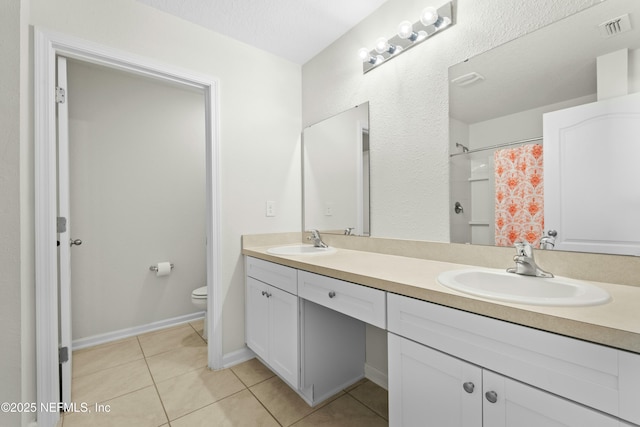 bathroom featuring tile patterned floors, visible vents, toilet, and a sink