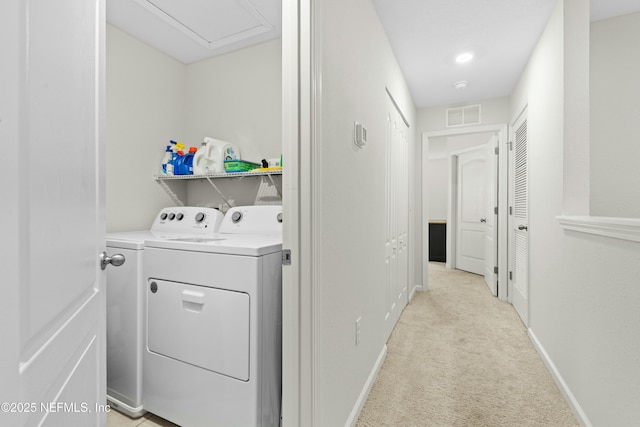 clothes washing area with baseboards, visible vents, laundry area, light carpet, and washer and clothes dryer