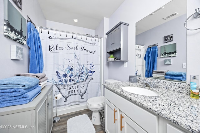 bathroom with visible vents, toilet, a shower with curtain, wood finished floors, and vanity