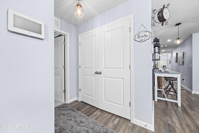 corridor with visible vents, baseboards, and wood finished floors