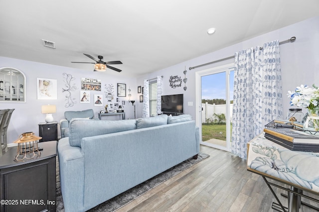 living room featuring visible vents, ceiling fan, and wood finished floors