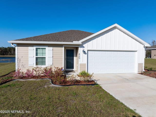 view of front facade featuring an attached garage, concrete driveway, a front lawn, and roof with shingles