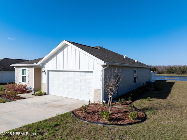 view of side of home with a lawn, driveway, central AC, board and batten siding, and a garage