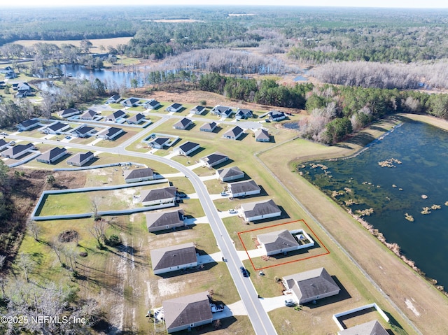 birds eye view of property featuring a residential view, a wooded view, and a water view