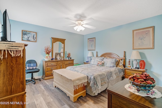 bedroom featuring light wood finished floors, baseboards, and ceiling fan