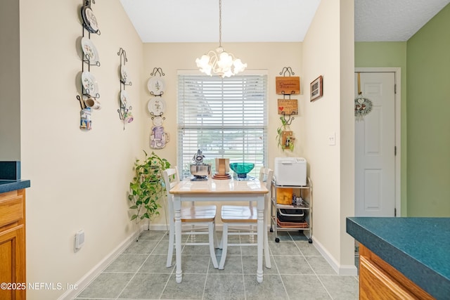 dining area featuring a chandelier, light tile patterned floors, and baseboards