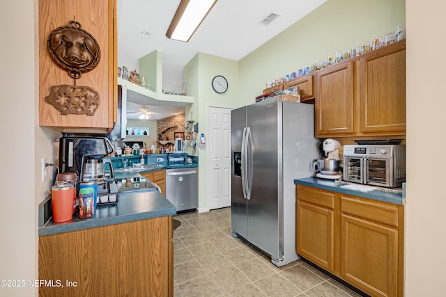 kitchen with visible vents, a toaster, ceiling fan, stainless steel appliances, and dark countertops