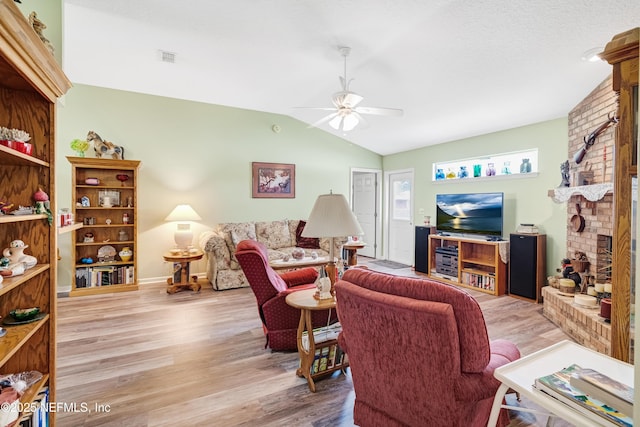 living area with vaulted ceiling, a ceiling fan, light wood-type flooring, and baseboards