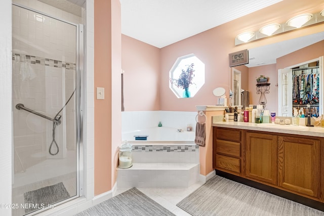 bathroom featuring tile patterned flooring, a stall shower, vanity, and a bath