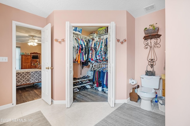 interior space featuring visible vents, tile patterned flooring, ensuite bathroom, a textured ceiling, and toilet