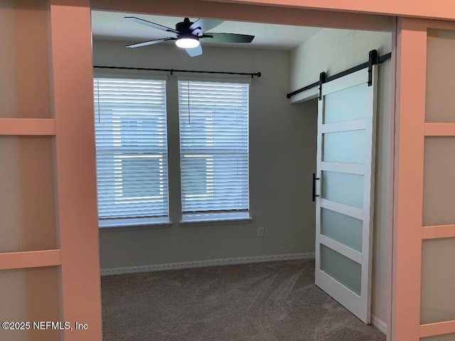 interior space with a barn door and ceiling fan