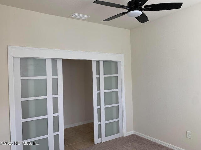 empty room featuring baseboards, visible vents, and ceiling fan