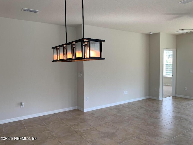 spare room featuring visible vents and baseboards