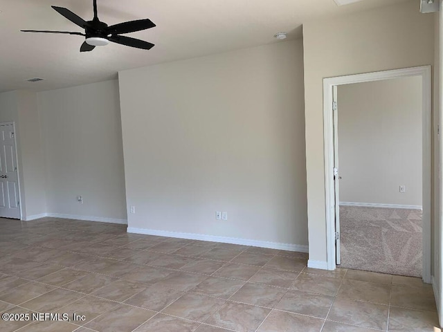 unfurnished room featuring light tile patterned floors, a ceiling fan, and baseboards