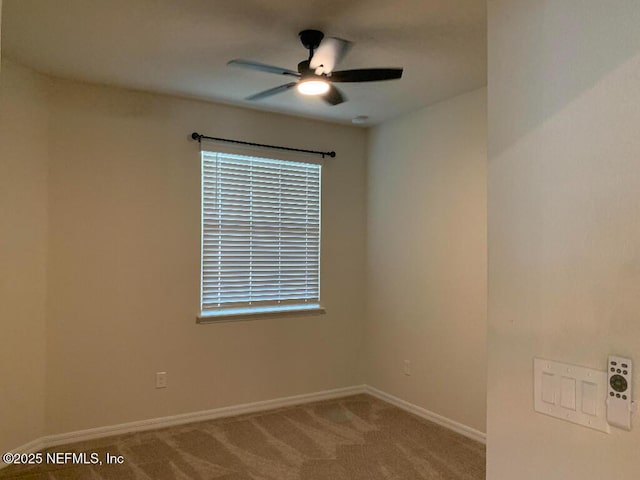 spare room featuring carpet flooring, baseboards, and a ceiling fan