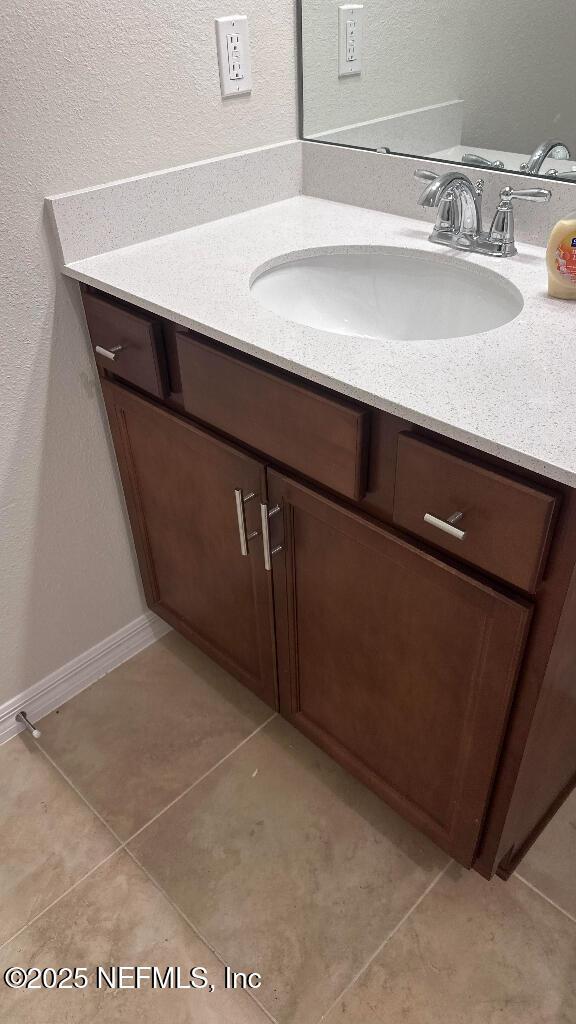 bathroom featuring tile patterned flooring, vanity, and baseboards