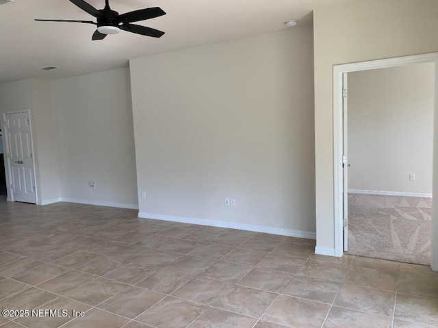 empty room with light tile patterned floors, visible vents, baseboards, and ceiling fan