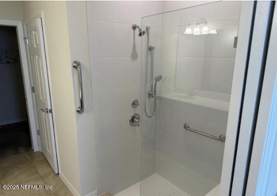 bathroom featuring tile patterned floors and a shower stall