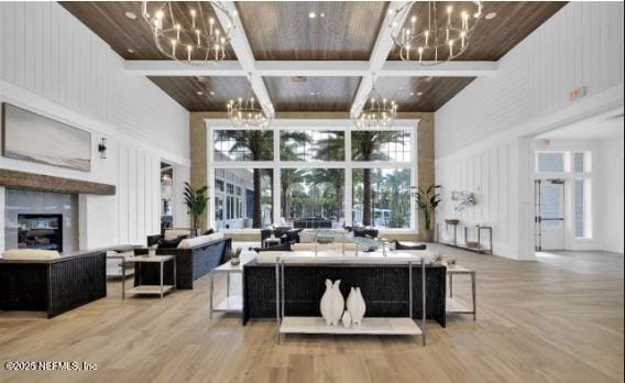 living room with coffered ceiling, a notable chandelier, wood ceiling, and a towering ceiling