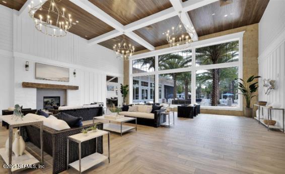 living area featuring coffered ceiling, wood ceiling, a chandelier, and a towering ceiling