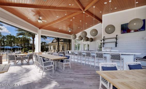 deck featuring outdoor dry bar, outdoor dining area, and a ceiling fan