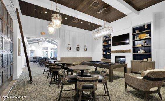 dining space with a glass covered fireplace, wooden ceiling, and built in shelves