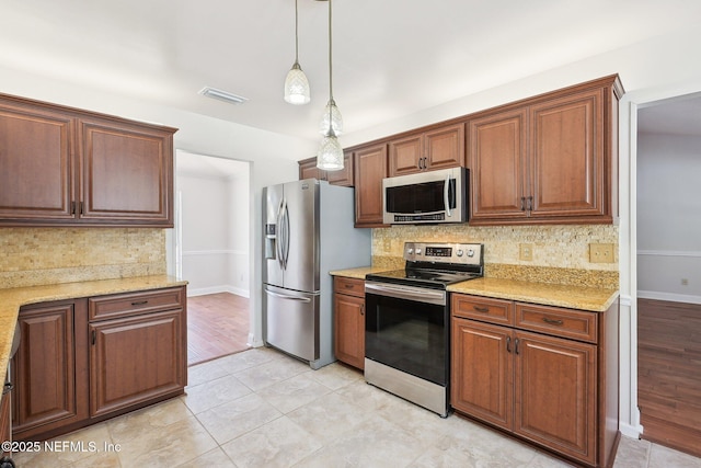 kitchen with light stone counters, visible vents, stainless steel appliances, decorative backsplash, and decorative light fixtures